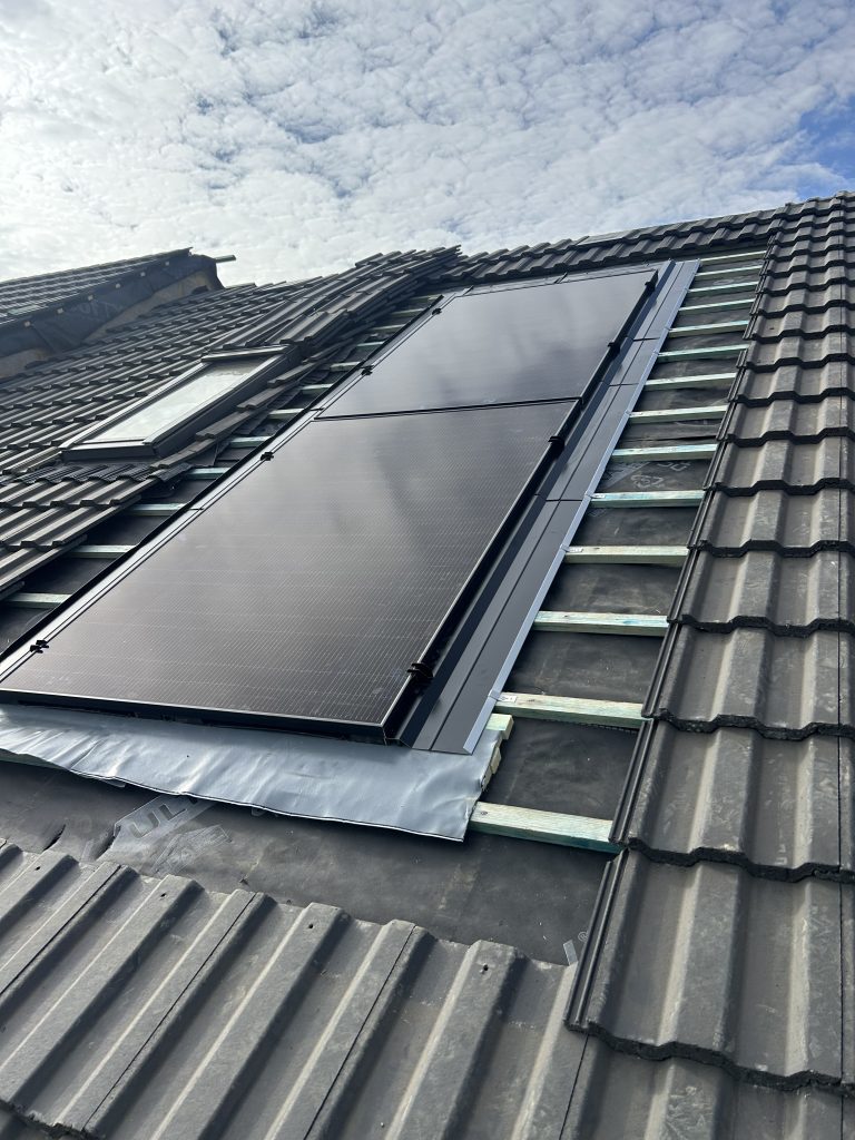 Solar panels being installed within a tiled roof